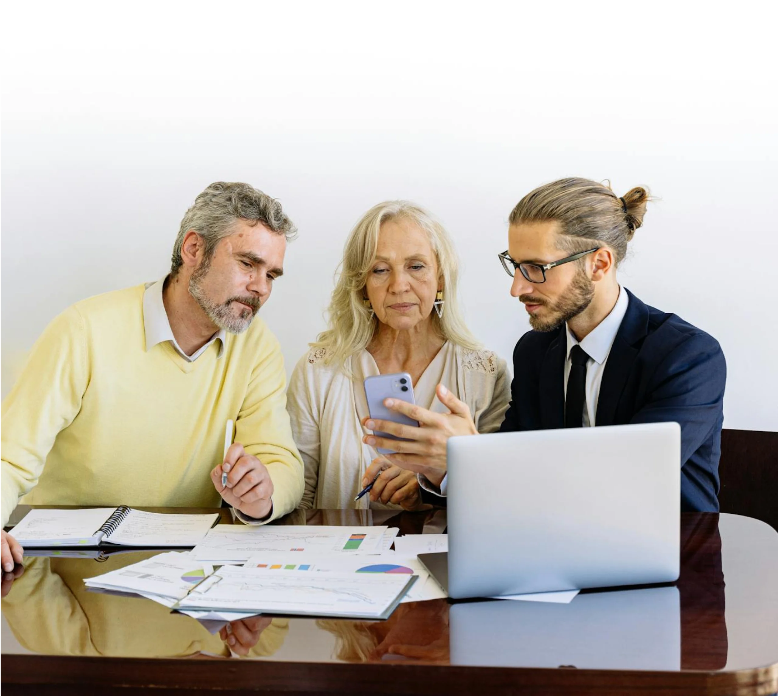 Business team reviewing data on phone and laptop in meeting